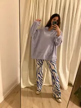 Combo de canguro con capucha color naranja y pantalón de jogging negro.