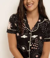 Camisón corto estilo americano confeccionado en viscosa certificada con estampado de estrellas y planetas. Tiene cuello solapa, abotonado delantero y bies contrastante.