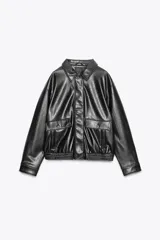 Chaqueta bomber negra de efecto piel, con cuello solapa y manga larga acabada en puño con botón. Tiene bolsillos de vivo en el delantero, bajo con elástico y cierre frontal con cremallera metálica y solapa con botones.