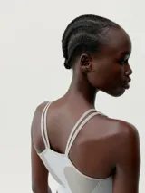 Top deportivo color gris con textura acanalada, tirantes finos y logo en el frente.