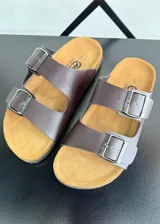 Sandalias marrones con plantilla color suela y doble tira con hebilla metálica.