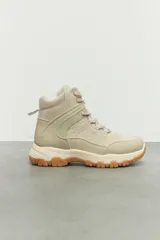 Botas tipo hiking color beige, de símil cuero, nylon y goma. Suela con relieve y cordones a tono. Son acolchonadas por dentro, lo que proporciona comodidad y abrigo.