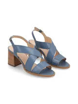 Sandalia de cuero color beige y blanco, con taco de madera y hebilla metálica.