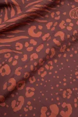 Vestido largo hasta el tobillo color marrón con estampado animal, breteles finos y escote en V profundo con detalle de flor.