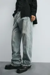 Pantalón de jean celeste de corte amplio con efecto lavado. Tiene cinco bolsillos y costuras frontales en las piernas.