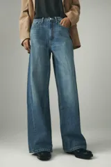 Jeans de tiro alto con pierna ancha y largo completo. Confeccionados en tejido rígido con cinco bolsillos, cintura con trabillas, detalle de costuras torcidas y cierre con cremallera y botón metálico.