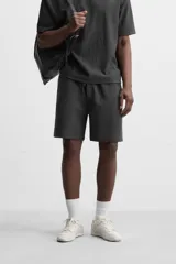 Bermuda negra de corte relaxed fit, con cintura elástica ajustable con cordón, bolsillos frontales y bolsillo trasero de parche.