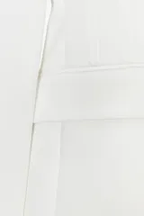 Blazer blanca entallada con cuello solapa combinado, manga larga con hombreras, bolsillos de plastrón en delantero, costuras marcadas, forro interior a tono y cierre frontal con botón forrado.