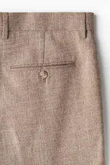 Pantalón de vestir color beige con textura de lino, corte recto, bolsillos laterales y traseros con botón. Cierre con cremallera y botón oculto.