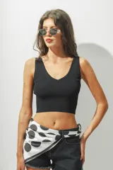 Top corto negro de tejido de punto acanalado, con escote en V y breteles anchos.