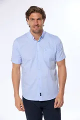 Camisa celeste con estampado de cuadros blancos, de manga corta, con cuello abotonado y bolsillo en el pecho.