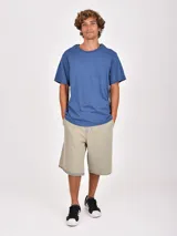 Remera de manga corta color verde oliva, con cuello redondo y un bolsillo frontal en el pecho.