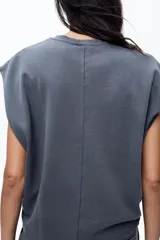 Camiseta azul de algodón con cuello redondo y mangas cortas caídas.
