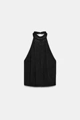 Top negro con cuello halter y espalda descubierta, con aplicación de brillos y cierre de botones en la espalda.