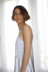 Camisón corto negro de satén con breteles finos y escote en V con puntilla blanca.