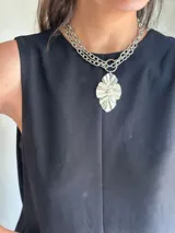 Collar plateado de doble cadena con dije colgante con forma de hoja.