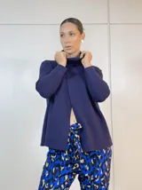 Polerón azul marino con cuello alto, corte holgado y mangas largas.