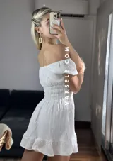Vestido corto blanco con escote off-shoulder, mangas cortas abullonadas y cintura elastizada.