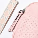 Porta celular color rosa con textura perforada, cierre superior y correa de tela estampada desmontable.