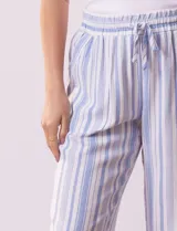 Pantalón de lino a rayas verticales color beige y blanco, con pretina ancha elastizada, lazo de ajuste y bolsillos inclinados.