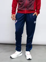 Pantalón de entrenamiento azul marino con logo de Umbro en blanco, corte ajustado y detalles en azul brillante en los tobillos.
