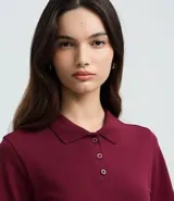 Blusa femenina color bordó, confeccionada en algodón piqué, con cuello estilo polo, mangas cortas y cierre frontal con botones.