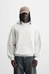 Sudadera con capucha gris confeccionada en tejido de algodón con interior rizo. Tiene manga larga, bolsillo frontal tipo canguro y acabados en rib.