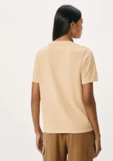 Camiseta color beige claro de algodón, corte recto, con escote en V y mangas cortas.