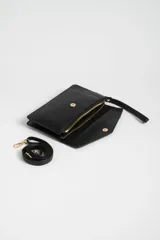 Bandolera negra de cuero sintético con solapa y correa larga ajustable.