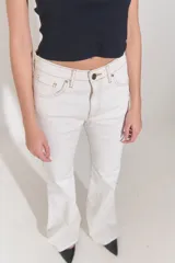 Jean oxford de tiro bajo, color azul oscuro, con cuatro bolsillos, pasacintos y cierre con cremallera y botón metálico.