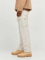 Pantalón cargo color beige de corte relajado con cierre de gancho y cremallera. Cuenta con bolsillos traseros, frontales y laterales, tiro medio y detalle de cordones en los dobladillos. Marca Jack & Jones.