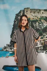 Vestido camisero corto negro con rayas verticales blancas, cuello mao, botones a tono y parche con logo en el frente.