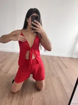 Top rojo con breteles finos, escote en V y detalle de nudo en el centro.