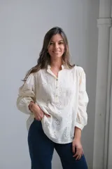 Blusa color crema con bordado calado, cuello mao y mangas largas abullonadas.