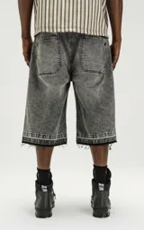 Bermuda denim larga color gris con efecto lavado, calce oversize, cintura con cinturón de ajuste y ruedo desflecado.