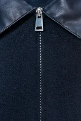 Chaqueta bomber azul marino de tejido de punto con cuello solapa de cuero sintético a contraste y manga larga. Cierre frontal con cremallera metálica.