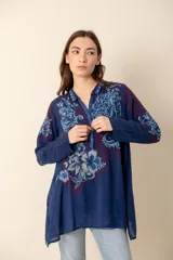 Túnica azul con bordados florales, cuello camisero y botones forrados.