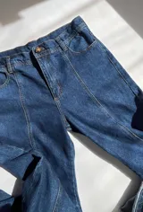 Conjunto de jean azul marino oscuro, compuesto por una chaqueta de corte holgado y un pantalón de tiro medio-bajo con corte vertical.