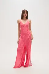 Pantalón largo de tela fluida con estampado de cebra en tonos rosa y fucsia. Tiene corte ancho y aberturas laterales con detalle de argollas.