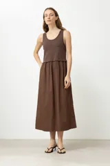 Vestido midi marrón con corte a la cintura, parte superior tipo musculosa y falda amplia.