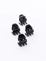 Set de cuatro pinzas pequeñas de plástico negro para el pelo.