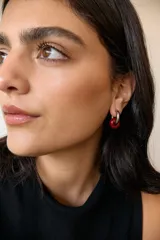 Aros de acero quirúrgico hipoalergénico con forma de argolla plateada y dije circular colgante de piedra natural color azul.