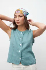 Chaleco color celeste con textura, corte recto, sin mangas y abotonado al frente.