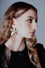 Aros colgantes con forma de estrella de mar dorada con textura irregular.