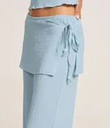 Pantalón celeste de corte recto, cintura alta, con canesú sobrepuesto y lazo lateral.