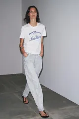 Camiseta blanca de cuello redondo y manga corta con estampado de texto en azul.