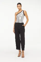 Blusa plateada de un hombro con ribete negro.