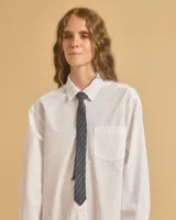 Corbata azul con finas rayas verticales blancas, confeccionada en lino.