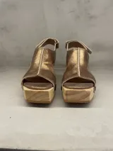Sandalias doradas de cuero con plataforma de madera, taco de 6,5 cm y detalle de tachas.