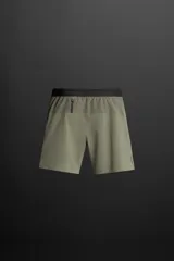 Shorts deportivos color gris oscuro confeccionados en tejido técnico ligero y elástico con forro interior, cintura elástica ajustable con cordón, bolsillos laterales, bolsillo de seguridad en espalda con cierre de cremallera, bajo con aberturas laterales y detalle de logo estampado en pernera.